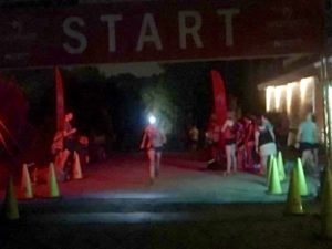 Runner with headlamp crossing finish line